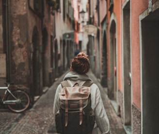 woman walking on street surrounded by buildings