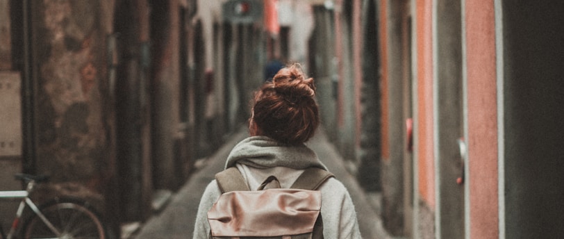 woman walking on street surrounded by buildings