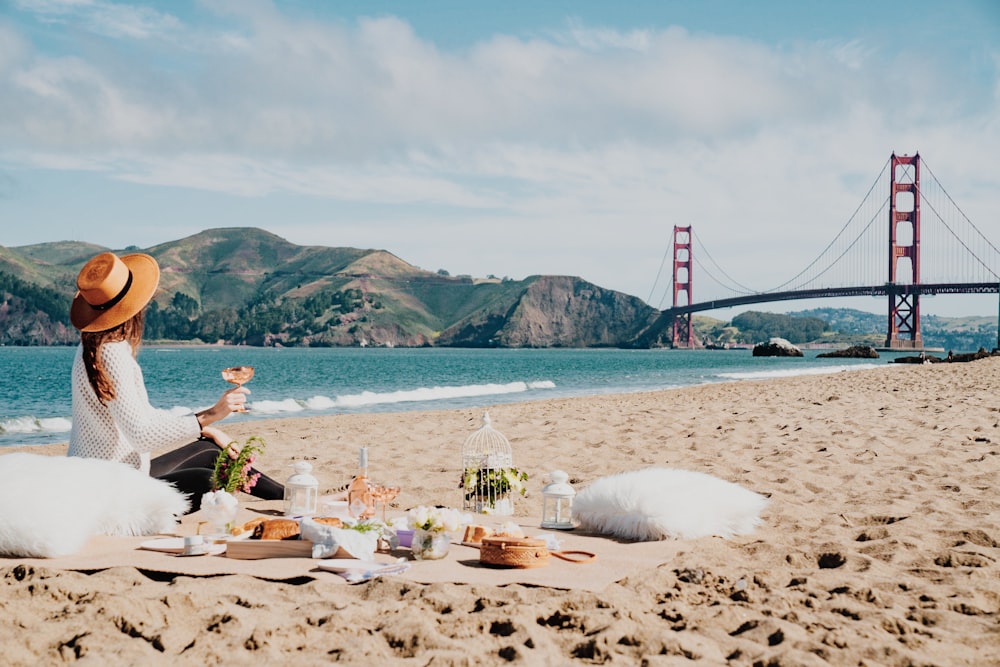 Frau sitzt in der Nähe der Küste und schaut auf Golden Gate, Sam Francisco