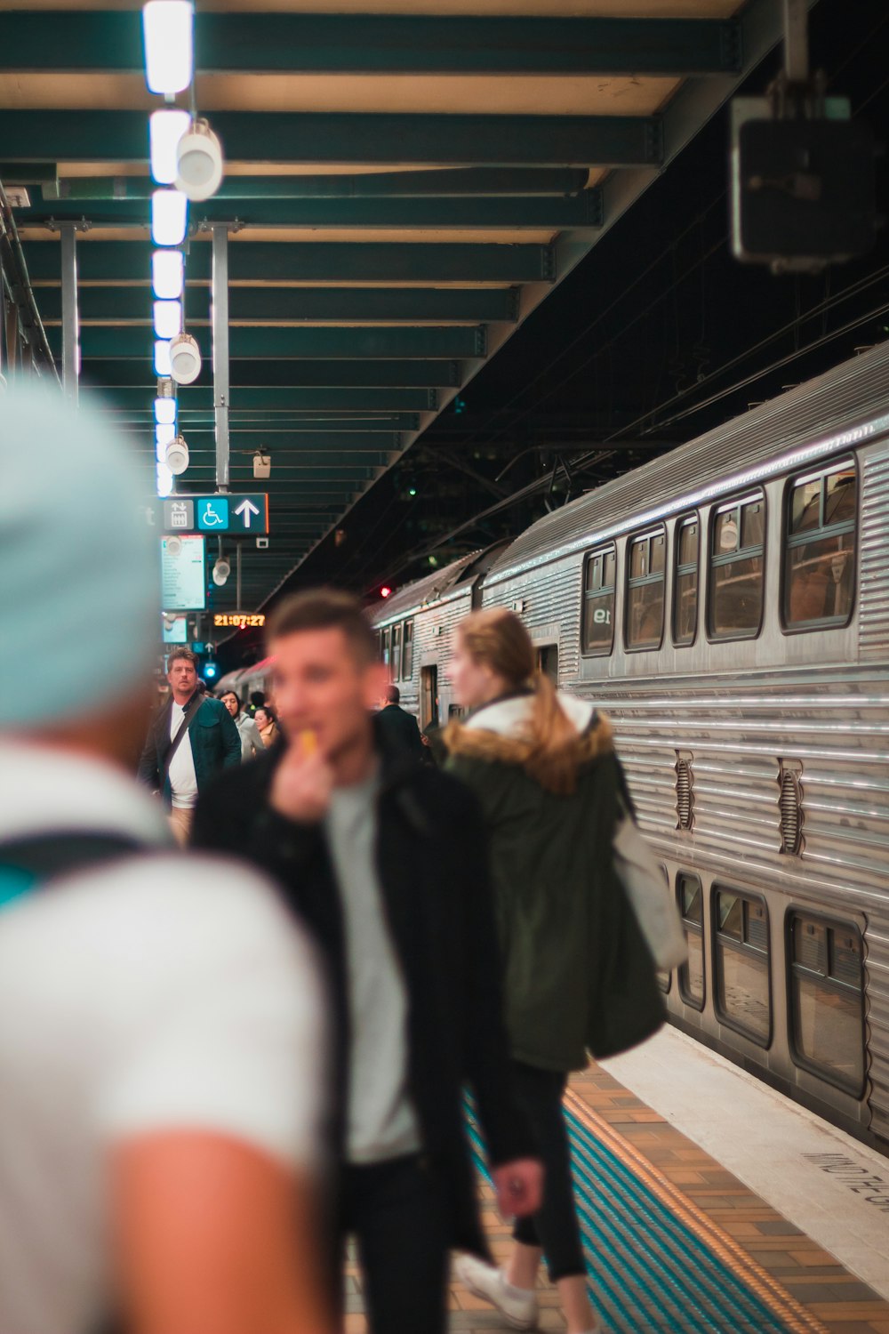 people standing on train station near train during nighttime