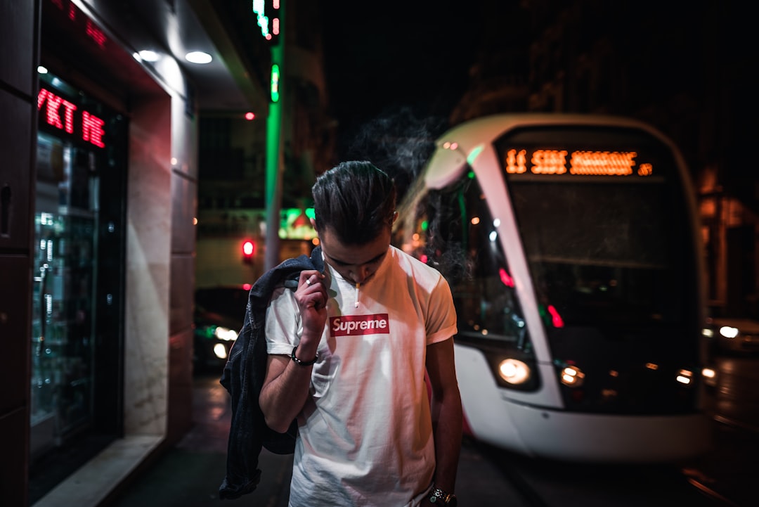 man holding jacket while standing near white vehicle