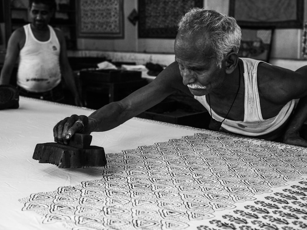 man stamping on white surface grayscale photography