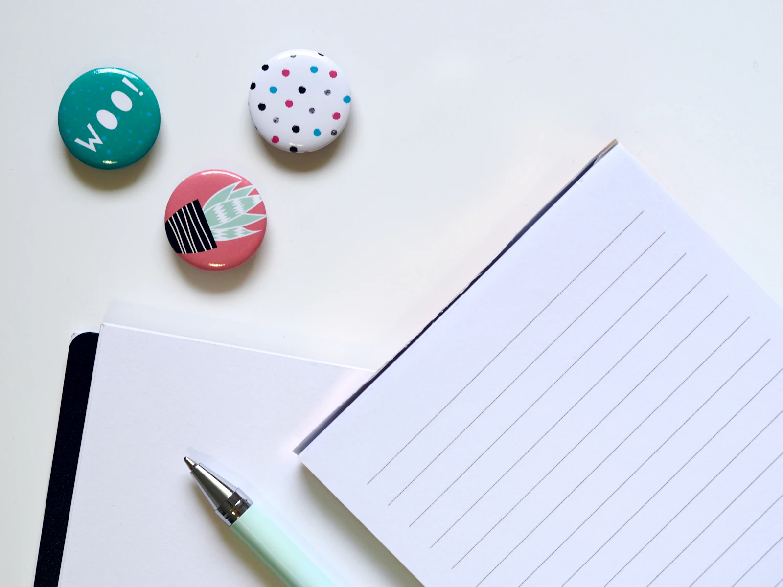 Pen resting beside a sheet of ruled notepaper