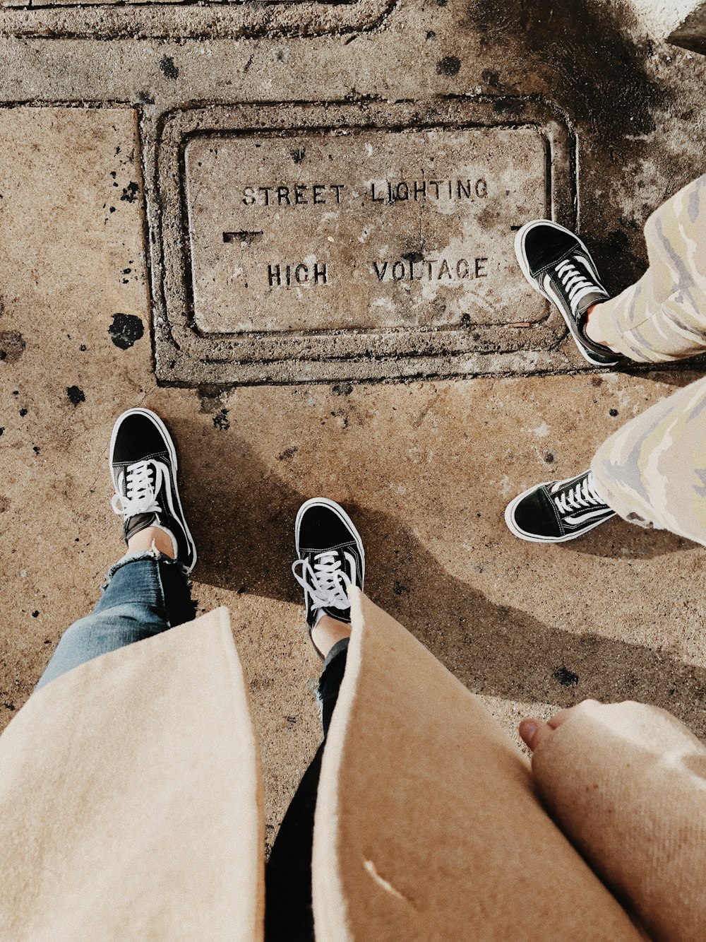 two person wearing pair of black Vans Old Skool low-top sneakers