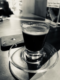 Close-up of a freshly brewed espresso alongside a smartphone displaying gsm 804 shop’s online store.