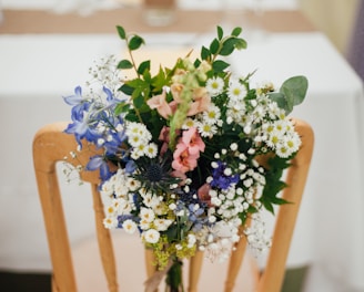 white petaled flowers on brown wooden armless chair