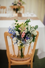 white petaled flowers on brown wooden armless chair