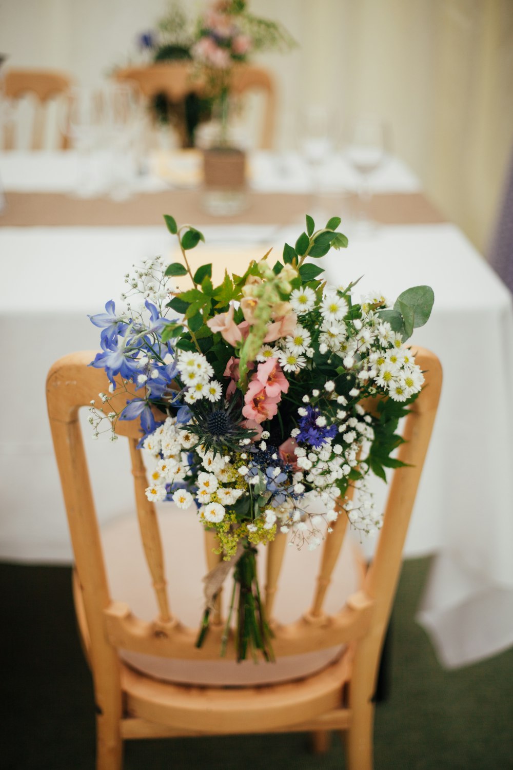 white petaled flowers on brown wooden armless chair