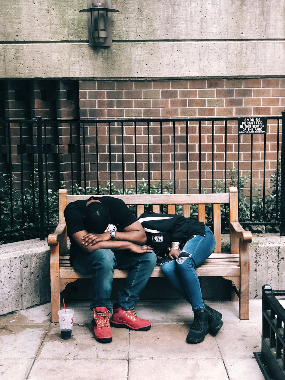 man sitting on bench beside lying woman