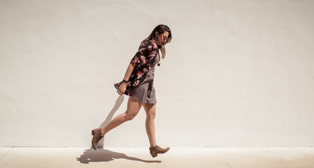 woman walking near white wall