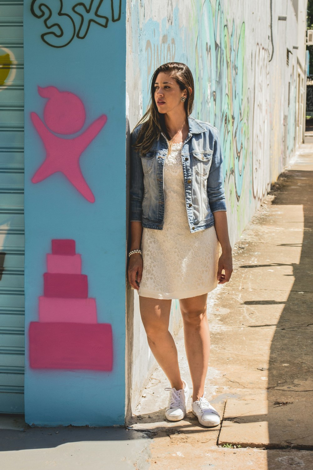 woman leaning on wall during daytime