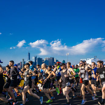 Runners crossing the finish line in a vibrant city race event.