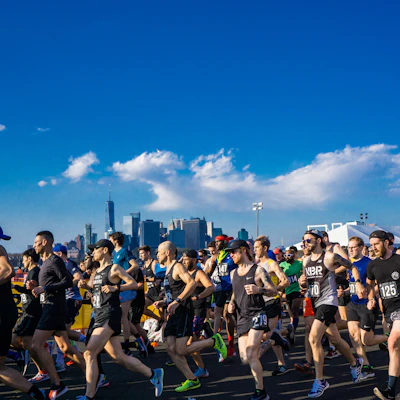 Runners crossing the finish line in a vibrant Murcia city race under a clear blue sky
