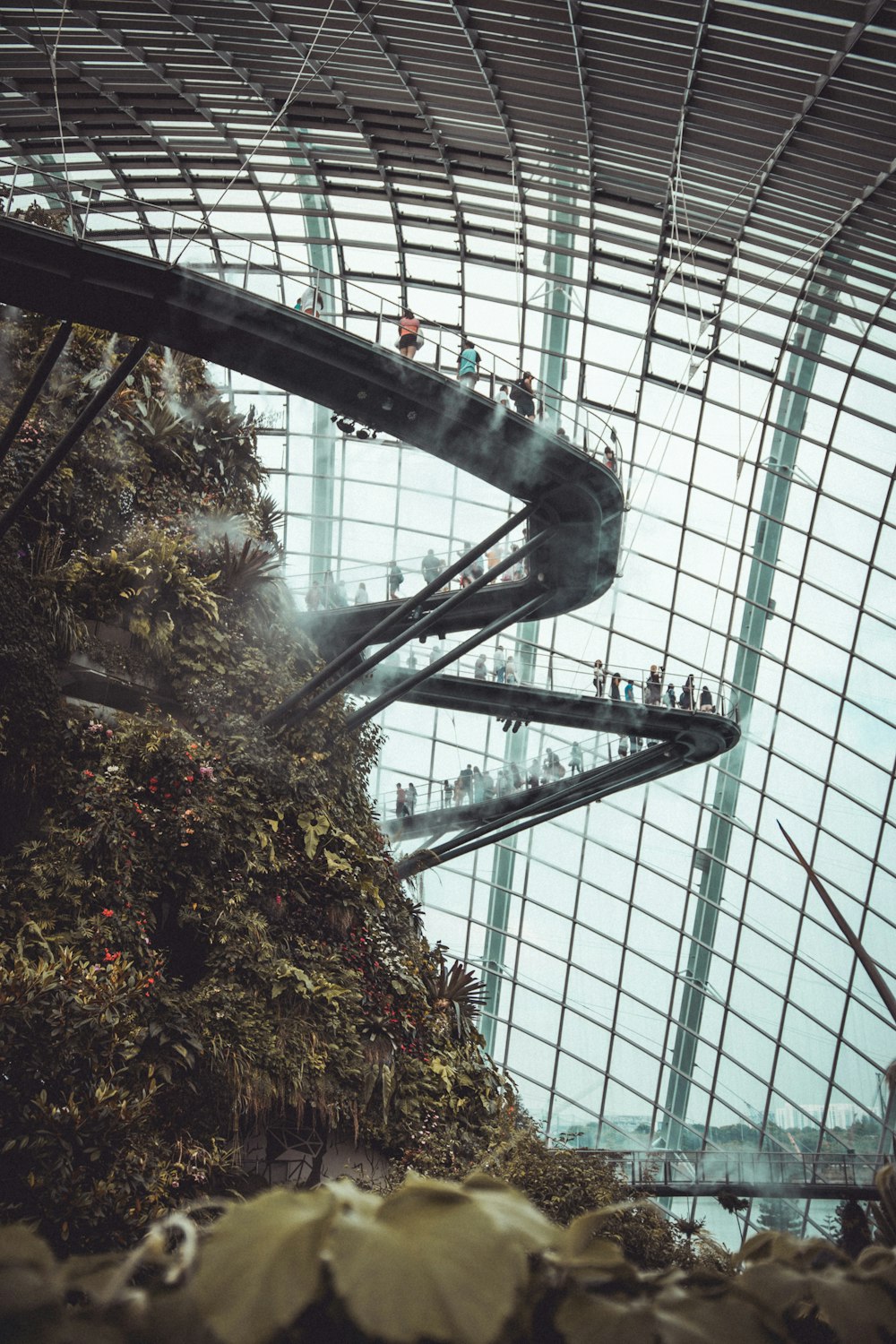 person inside a glass dome on a huge mound with stairs