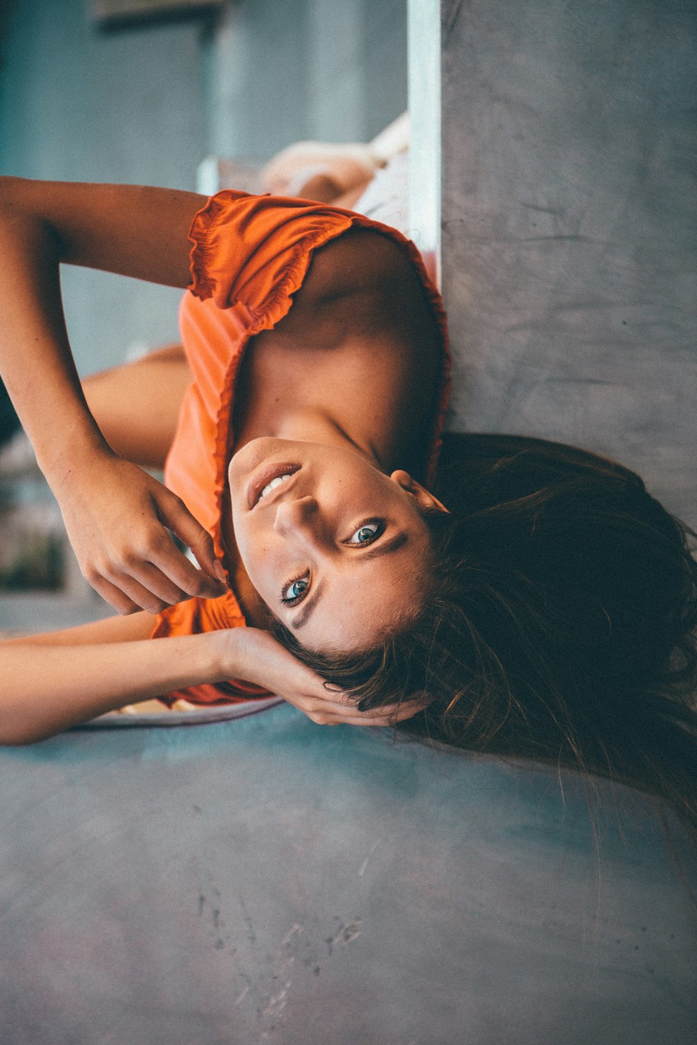 Mujer acostada cerca de una pared gris