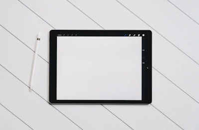 A clean, minimalist flat lay of a digital tablet displaying a manifestation ebook cover with soft neutral tones.