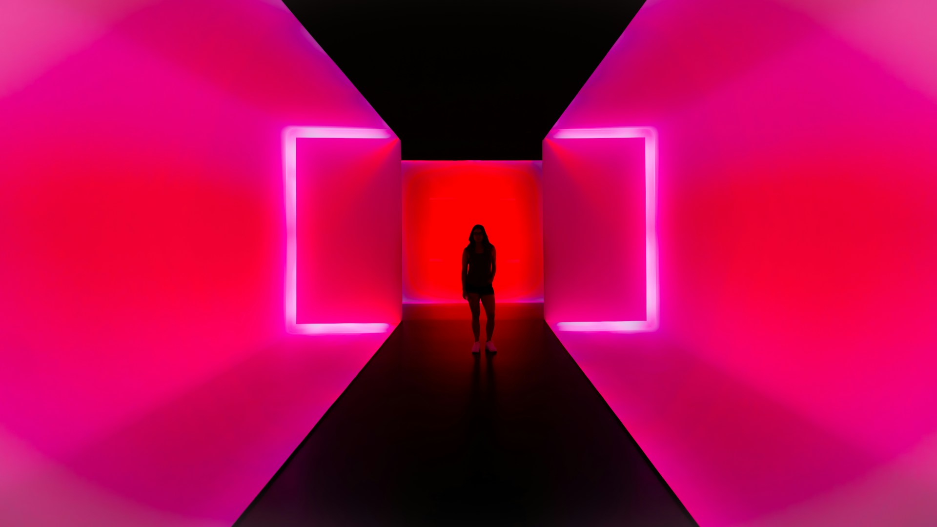 a person standing in a dark tunnel with bright lights