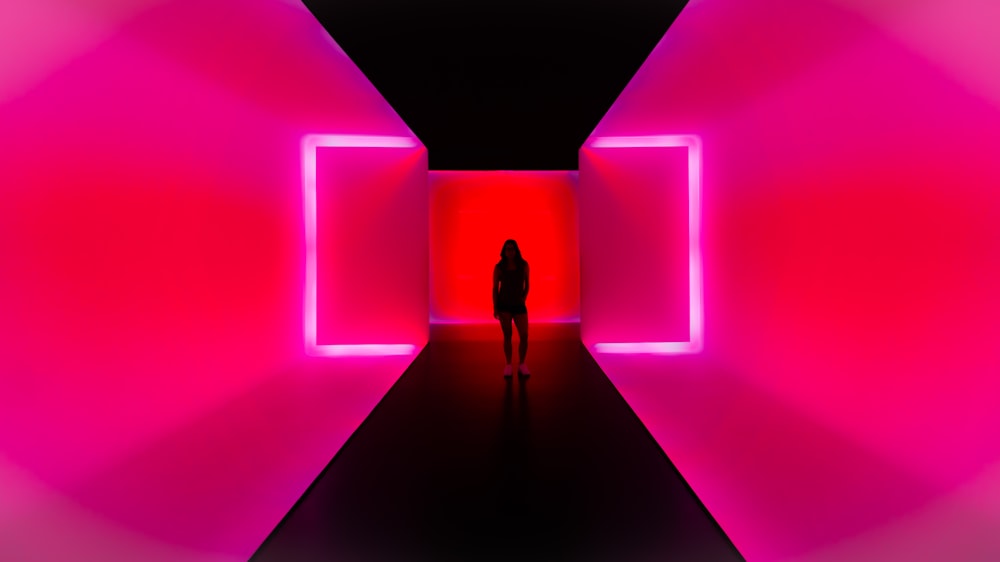 a person standing in a dark tunnel with bright lights