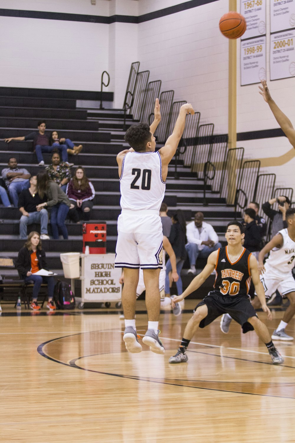 man in white and black number 20 jersey shirt shooting a basketball