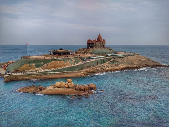 brown and green island surrounded by water in Vivekananda Rock Memorial India