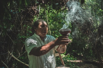 A serene shaman performing a cleansing ritual with smoke in a natural forest setting.