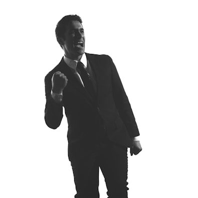 A candid photo of a young person celebrating a financial milestone with a fist pump.