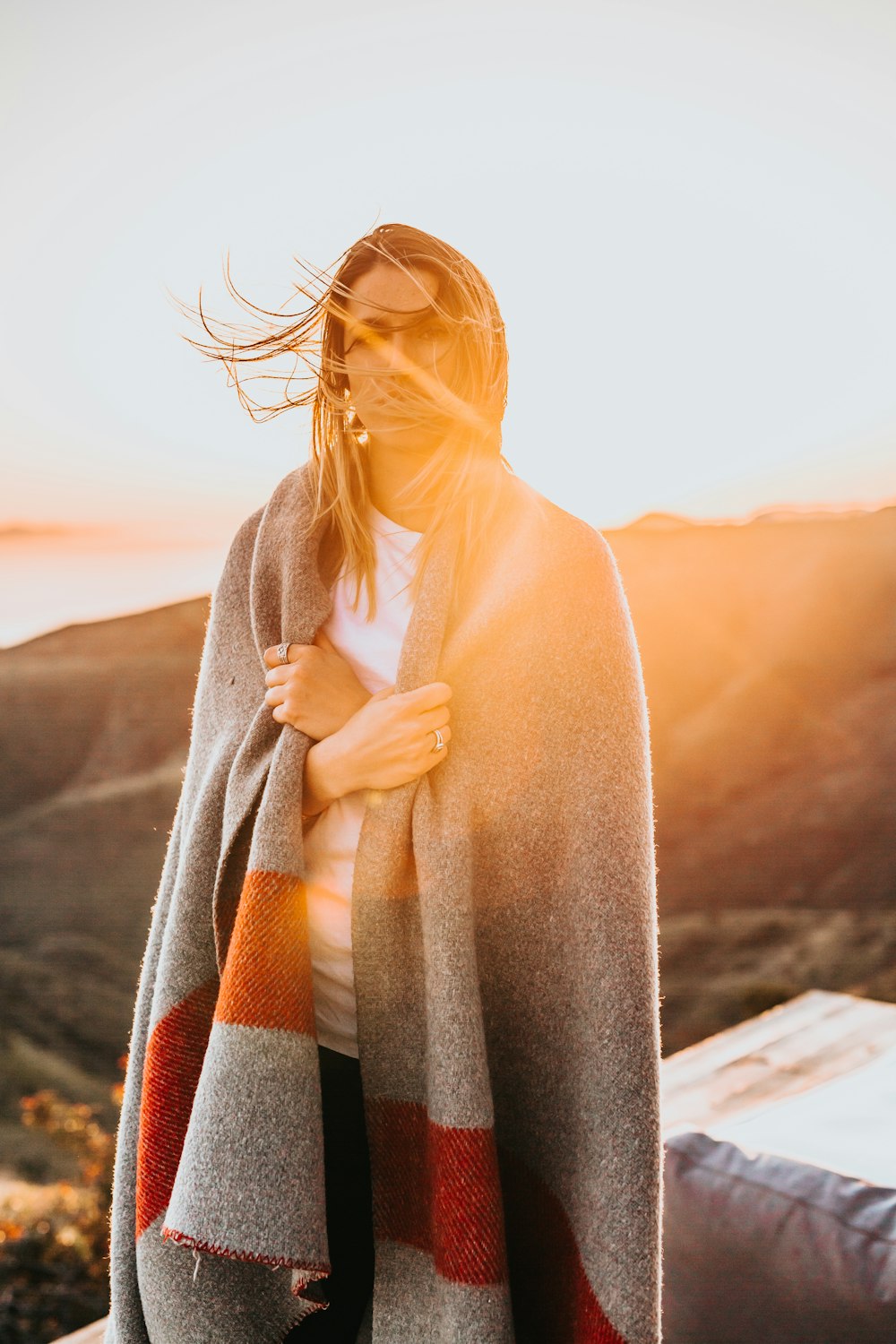 woman standing wearing gray and brown coat