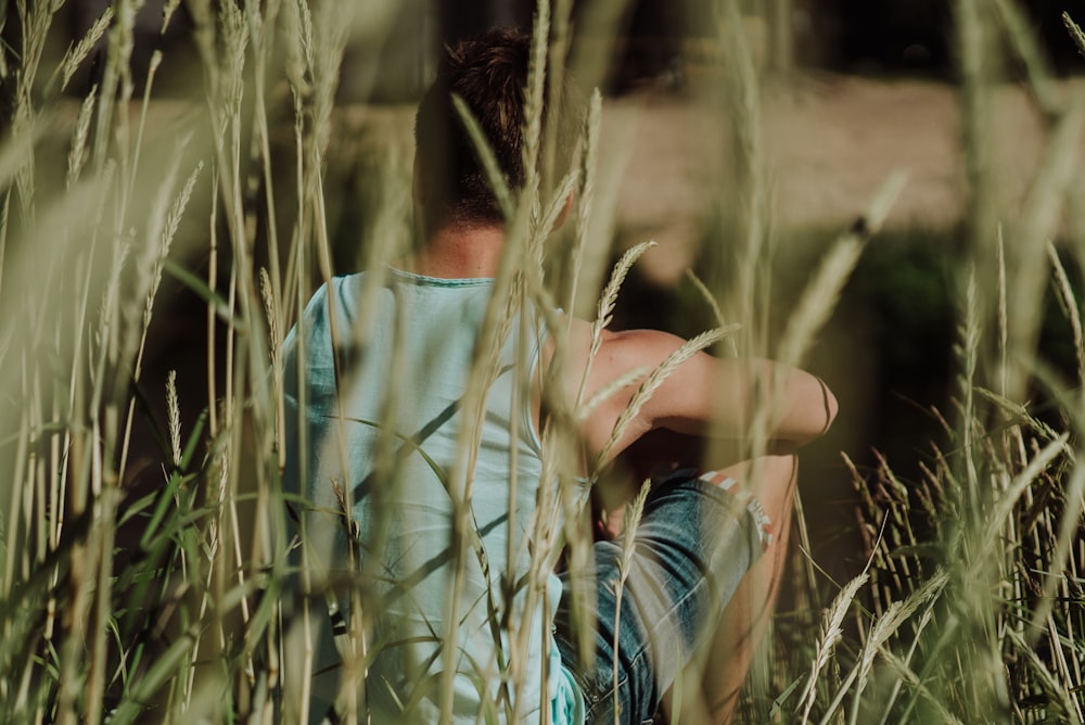 man sitting and surrounded by green gass