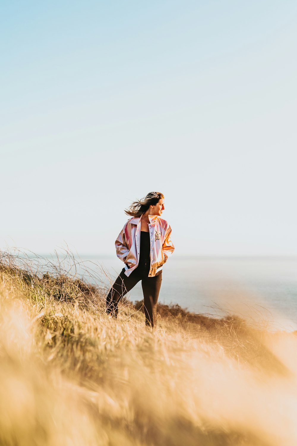 woman standing on grass field with both hands in pocket