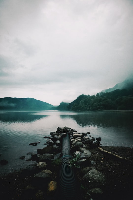 stone fragment beside body of water during daytime in Wales United Kingdom