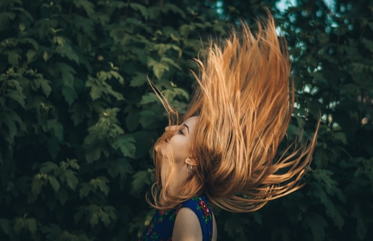 woman waving her hair beside green leafed plant in Iași Romania