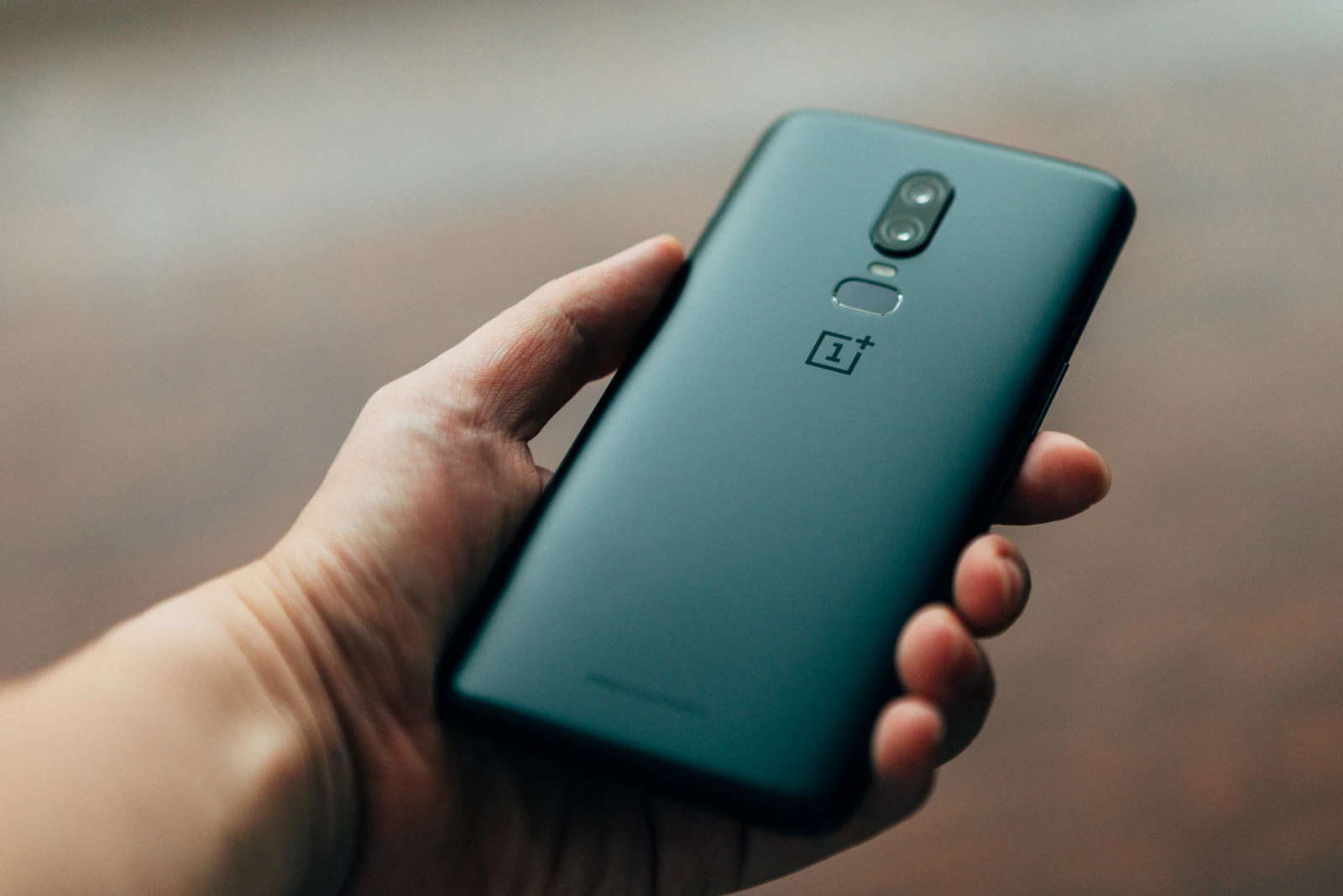 Person holding an Android smartphone with a fingerprint sensor