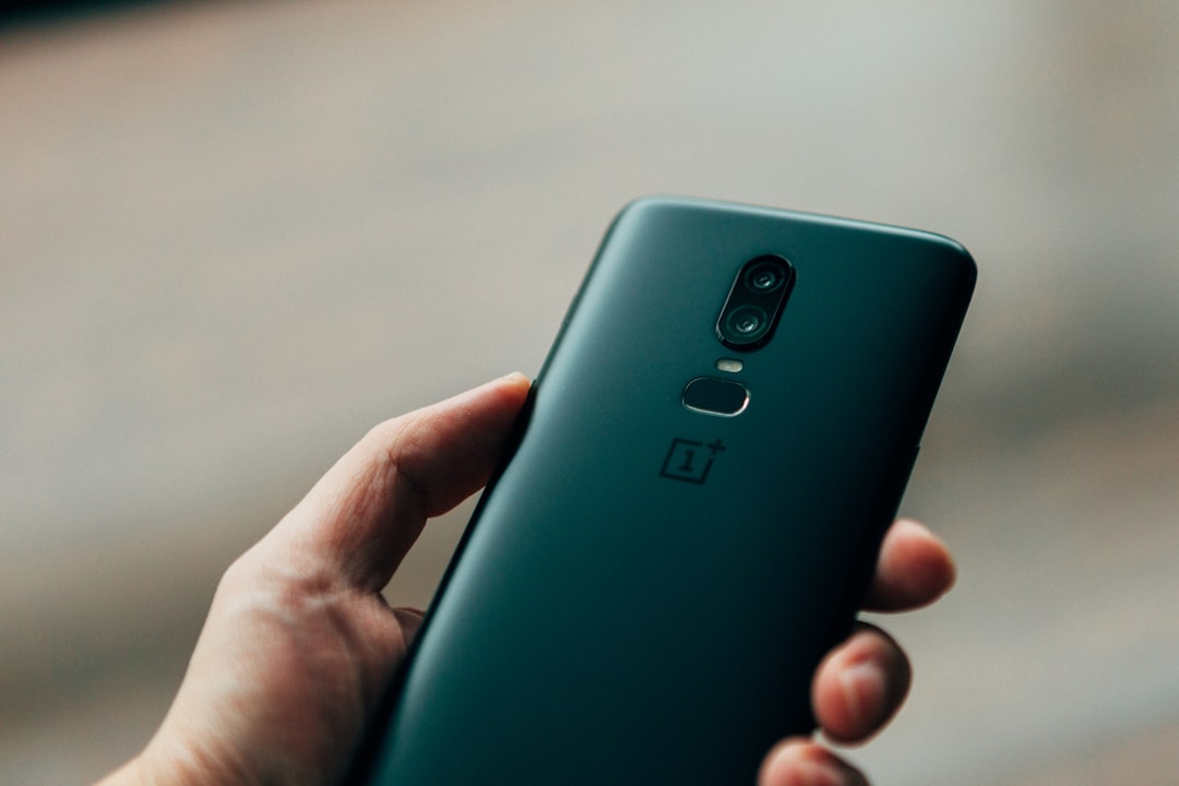 person holding black 1+ Android smartphone,