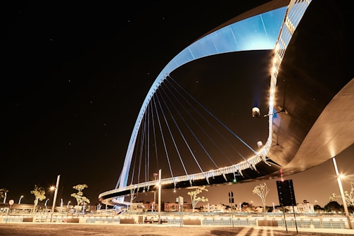 A sleek, modern urban bridge illuminated at dusk, showcasing clean lines and sturdy design.