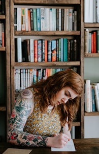 woman writing on white paper