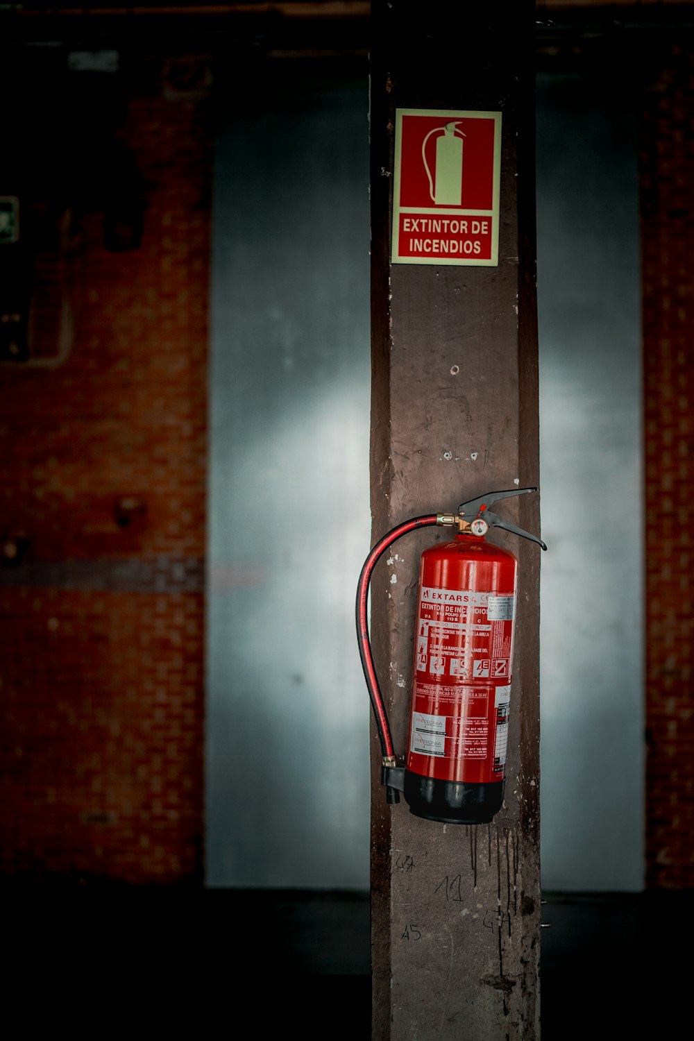 茶色の壁に吊るされた赤い消火器