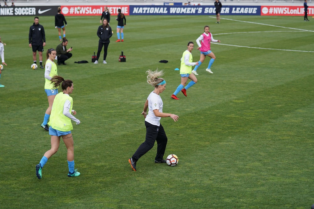 Grupo sobre mulheres que jogam futebol no campo de futebol durante o dia