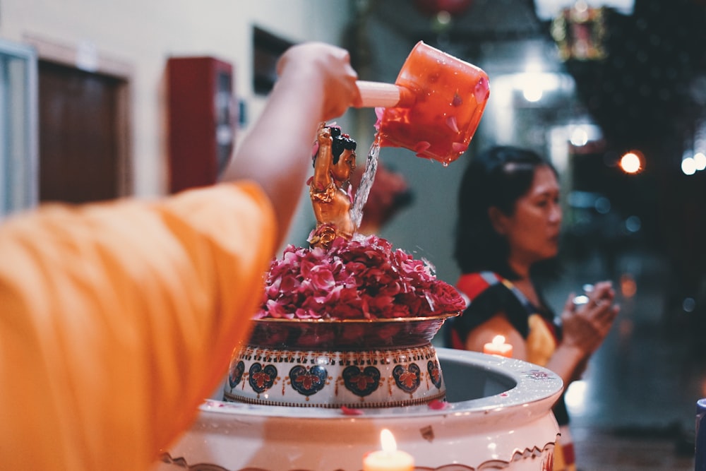 a person pouring a drink into a cup