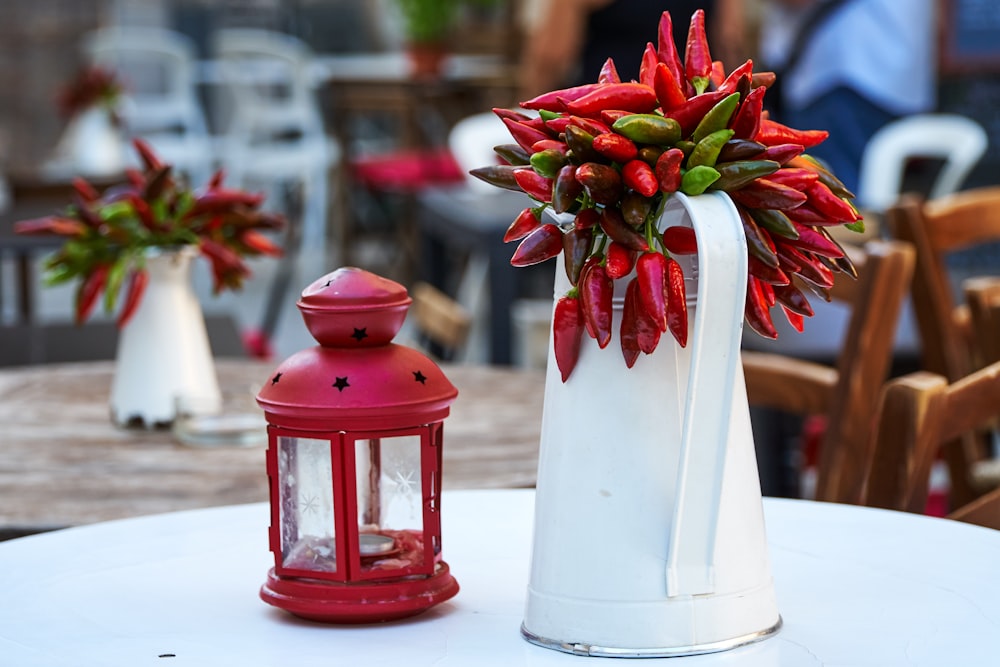 white pitcher beside red candle lantern