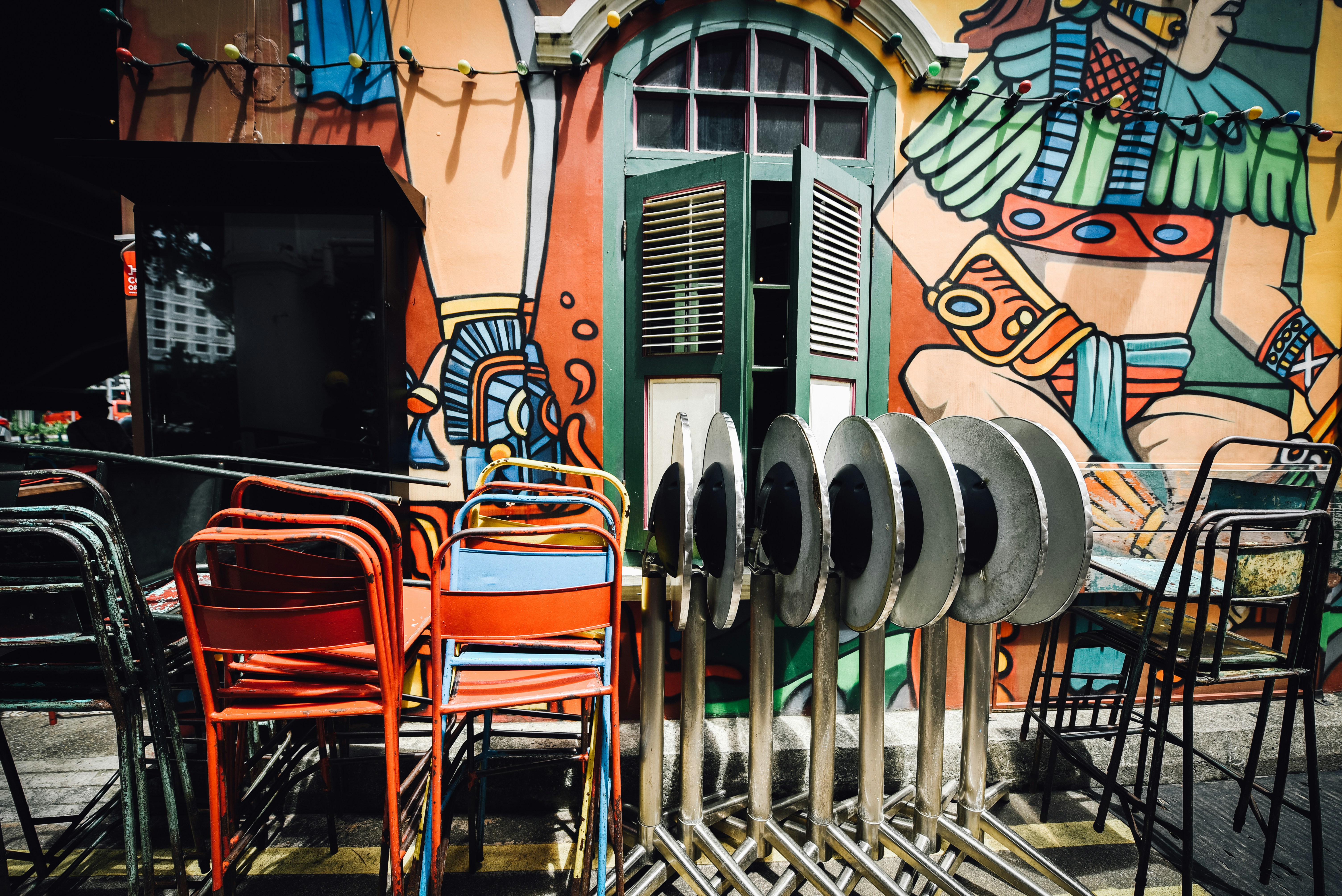 assorted-color metal chairs outside building wall art