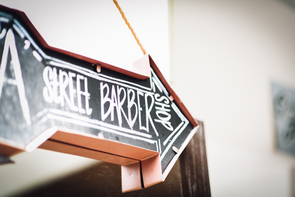 black and white Street Barbershop arrow signage