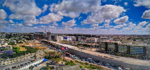Construction site of a wide, smoothly paved highway under clear blue skies, emphasizing large-scale infrastructure.