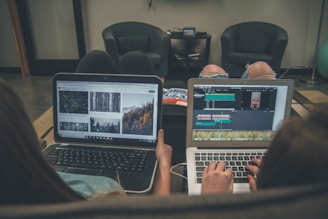 two person with laptop on lap sittig