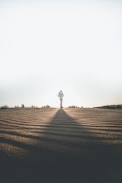 person wearing white dress shirt standing on gray surface
