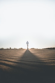 person wearing white dress shirt standing on gray surface