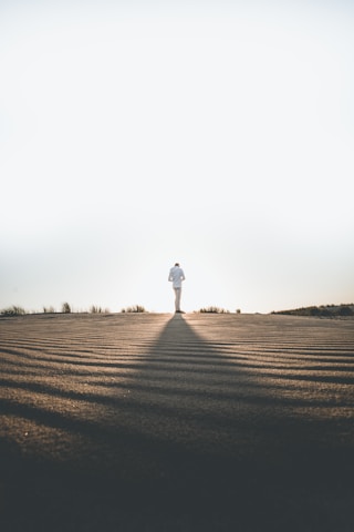 person wearing white dress shirt standing on gray surface