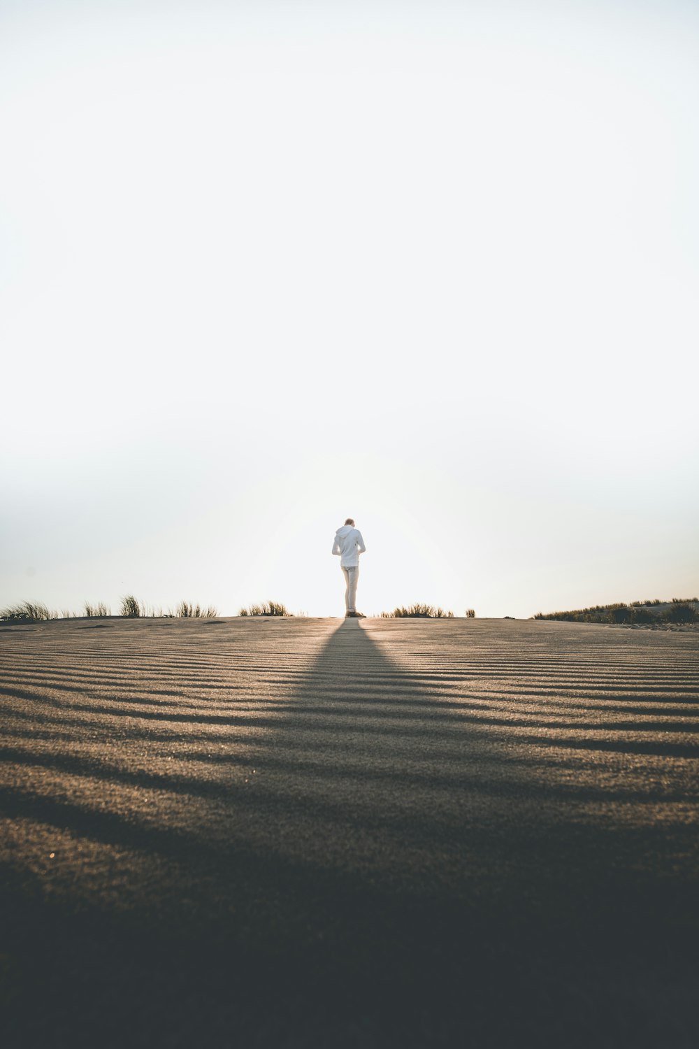 person wearing white dress shirt standing on gray surface