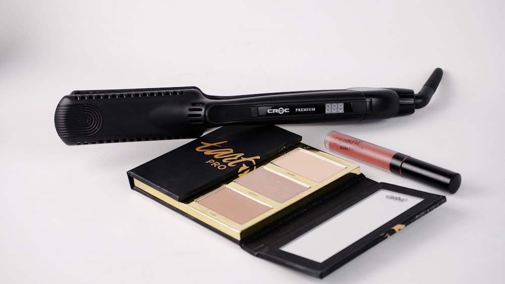 selective focus photography of hair flat iron and Tarte Pro eyeshadow palette