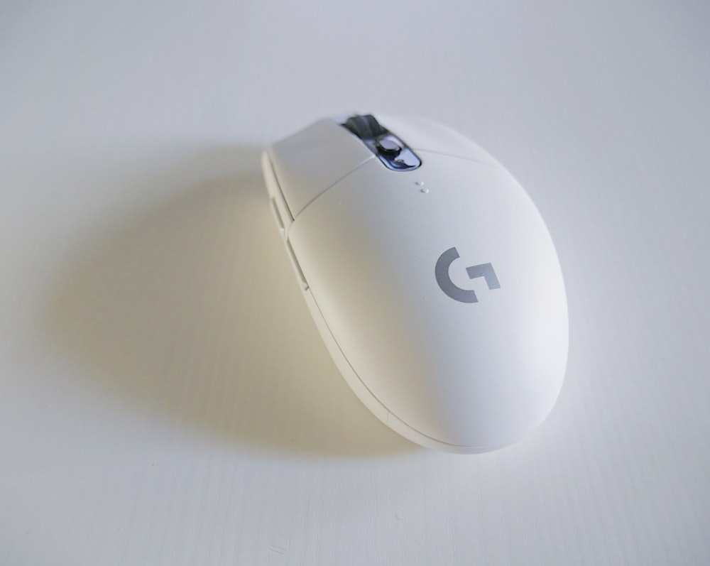 mouse sem fio Logitech G-Series branco e cinza em superfície branca