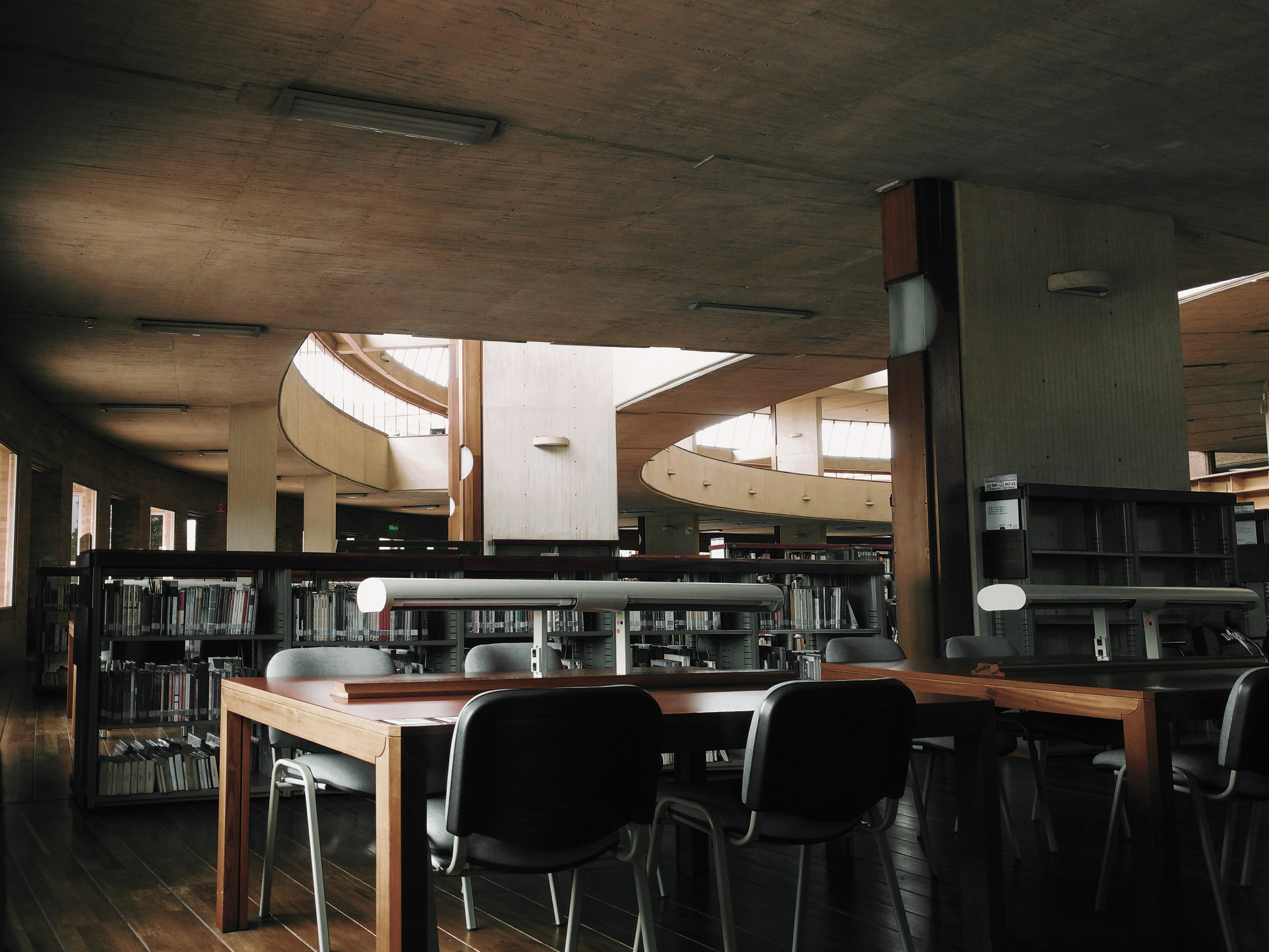 brown wooden desk with chairs inside the room